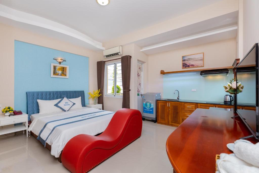 a bedroom with a bed and a red chair at Queen Garden Hotel & Apartment in Vung Tau
