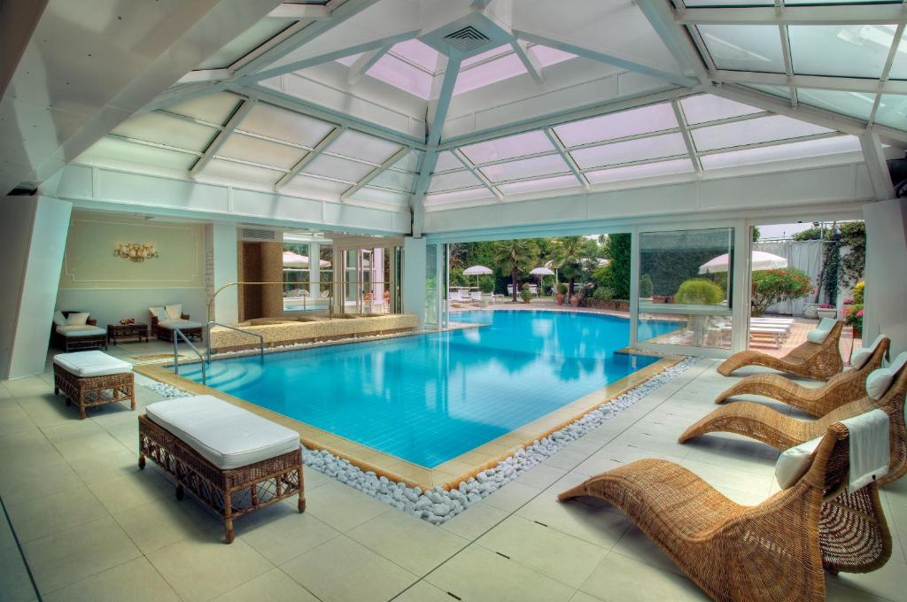una gran piscina con sillas y techo abierto en Hotel Terme Principe, en Abano Terme