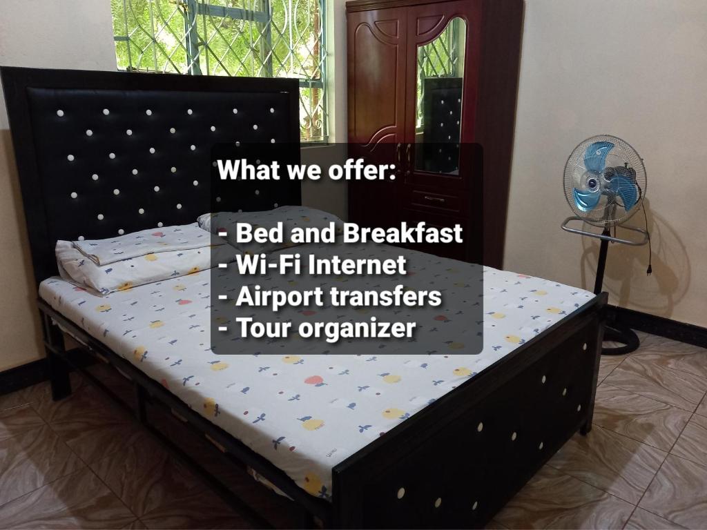 Airb&b Homestay في Boma la Ngombe: سرير في غرفة نوم مع لافتة مكتوب عليها السرير والافطار الانترنت witf