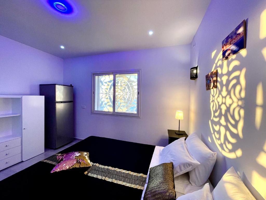 Habitación púrpura con cama y ventana en Master Suite in Bellavista Andalucia with Pool and Beach en Al Matlīn