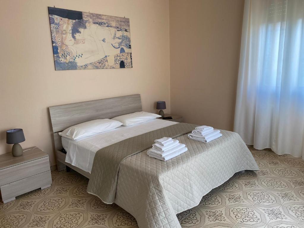 una camera da letto con un letto e due asciugamani di Casa vacanze La Pergola a Itri
