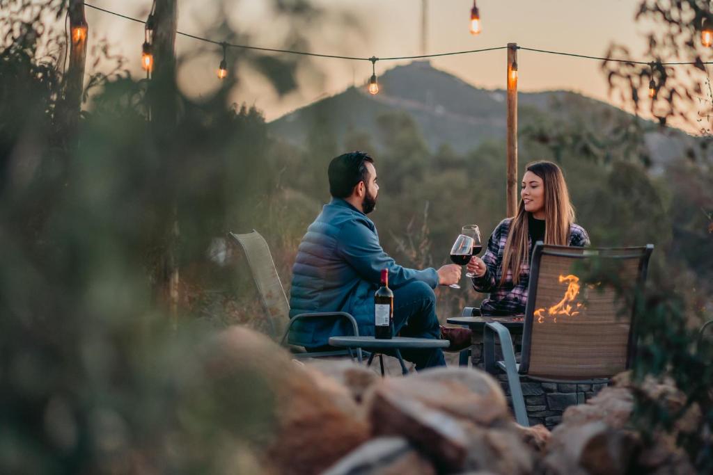 Ein Mann und eine Frau sitzen an einem Tisch mit Weingläsern. in der Unterkunft Oasis 444 in San Marcos