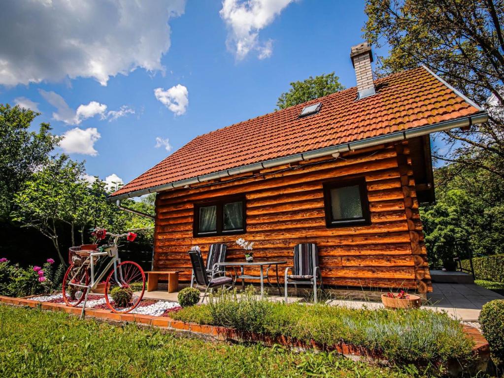 uma cabana de madeira com uma bicicleta estacionada em frente em Home Eden Dobrenica em Bihać