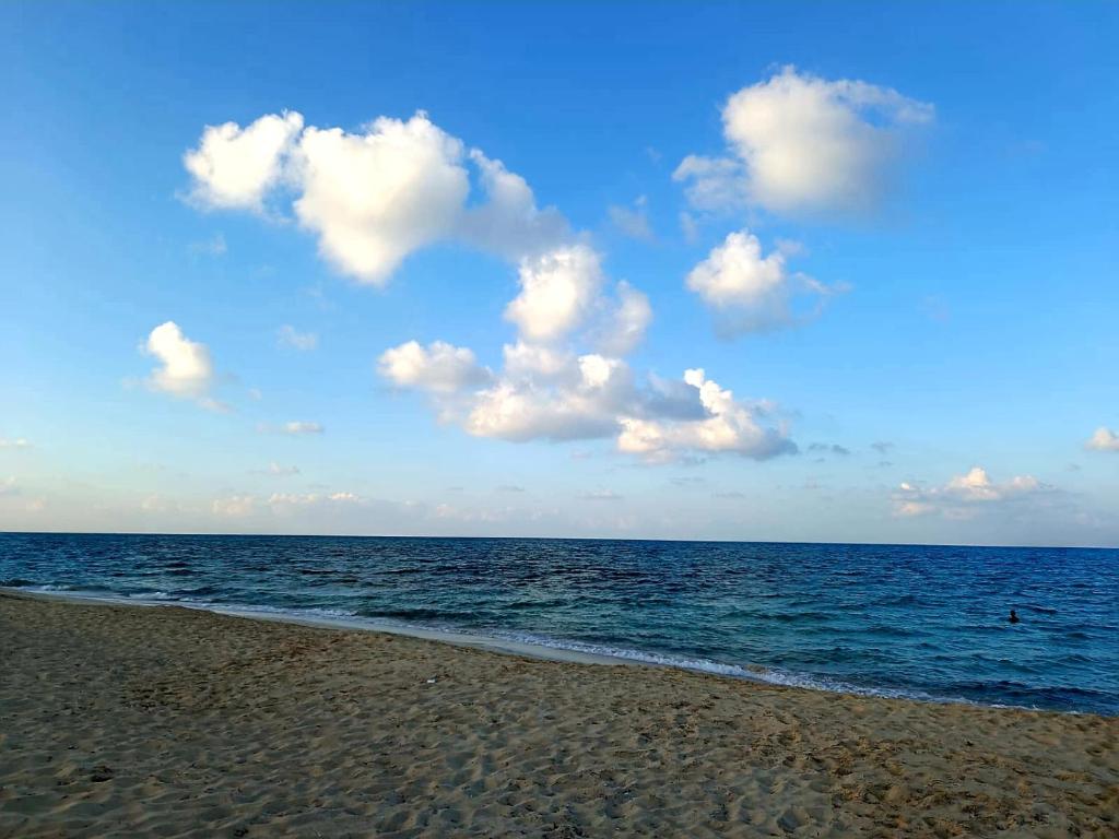 a beach with a cloudy sky and the ocean at فيلا راقية في منتجع سانتا مونيكا مرسي مطروح عائلات فقط in Marsa Matruh