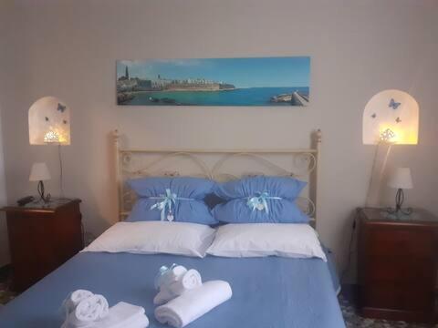 ein Schlafzimmer mit einem blauen Bett mit Handtüchern darauf in der Unterkunft Antonia Jess Central ,Near Beach- by Gessica homes in Monopoli
