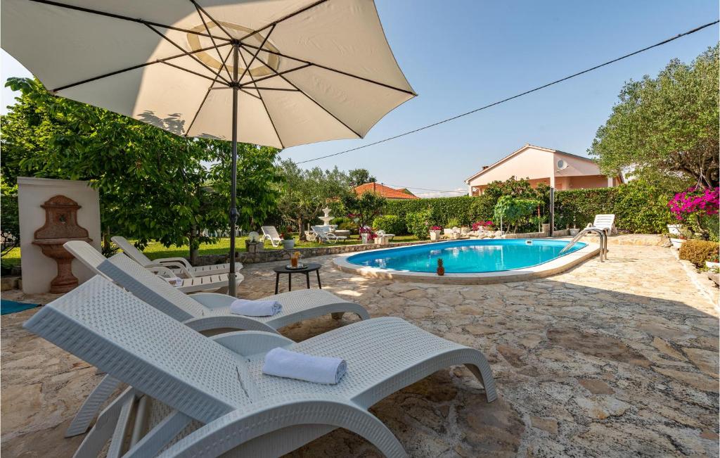 una piscina con una silla, una sombrilla y una piscina en Stunning Home In Lovinac With Wifi en Lovinac