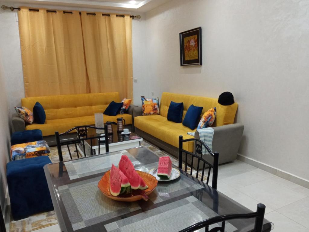 una sala de estar con sofás y una mesa con frutas. en SolMar 1 en Martil