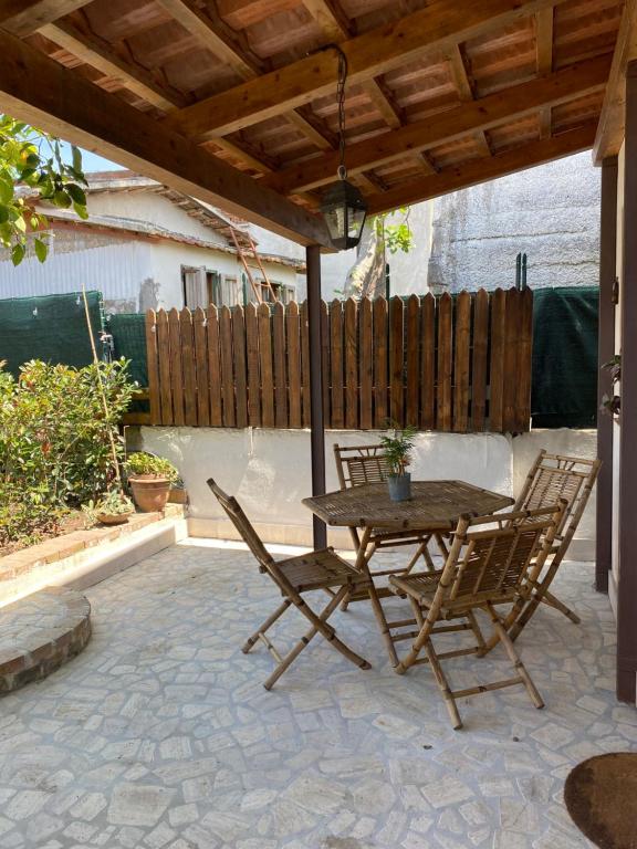 una mesa de madera y sillas en un patio en CasaMoltoCarina Cottage Garden en Minturno