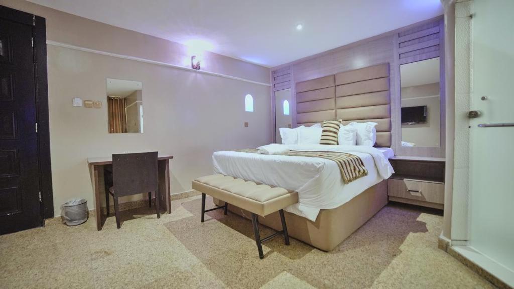 a large bedroom with a large bed and a desk at Ikeja Airport View in Lagos