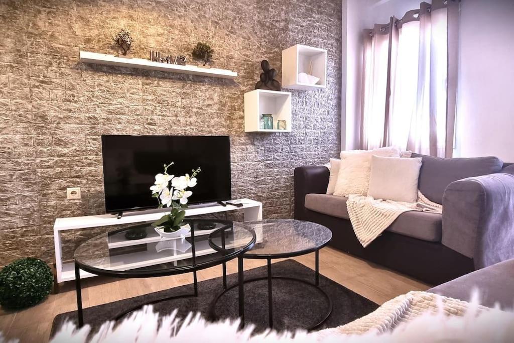 a living room with a couch and a table with a tv at Zeus in Gázion