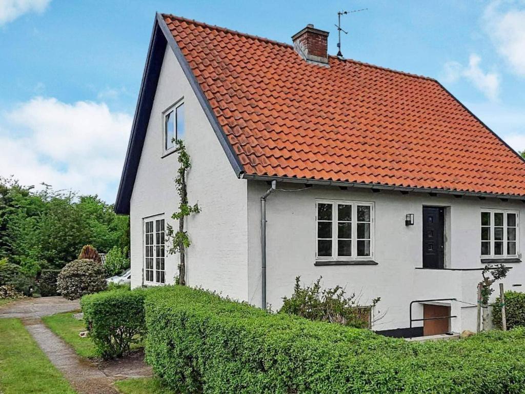 een wit huis met een oranje dak bij Holiday home Bindslev XVI in Bindslev
