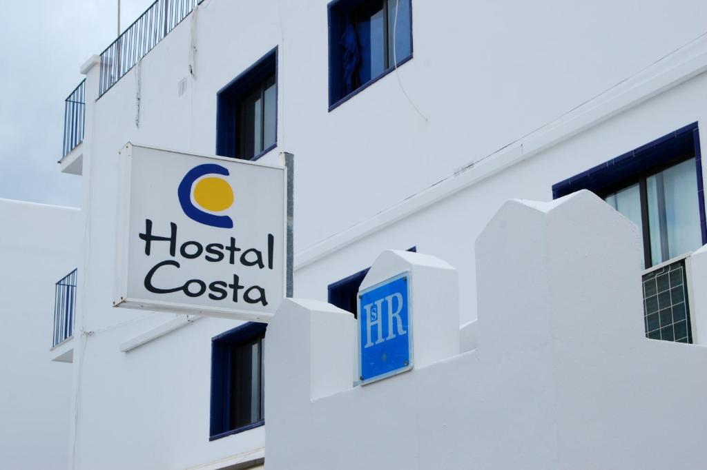 een ziekenhuis costa bord op de zijkant van een gebouw bij Hostal Costa in Ibiza-stad