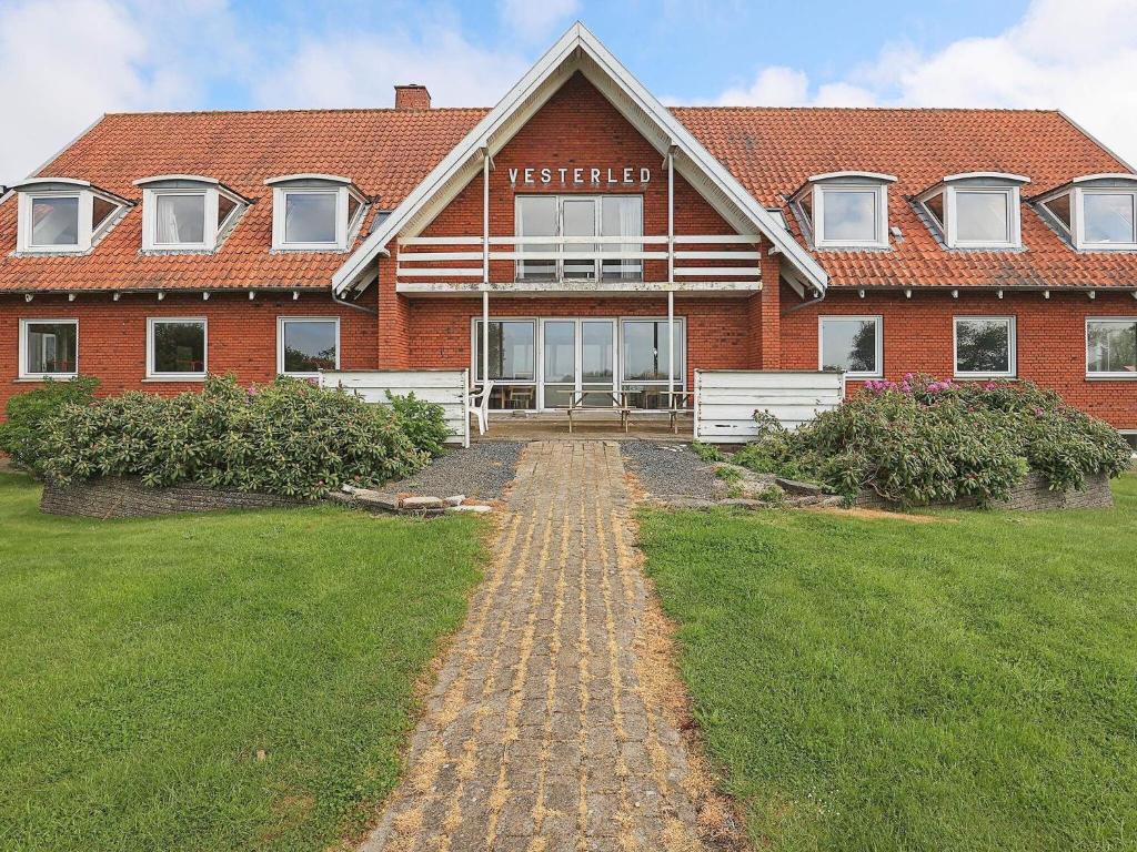 a red brick house with a sign on it at Fourteen-Bedroom Holiday home in Hurup Thy in Sindrup
