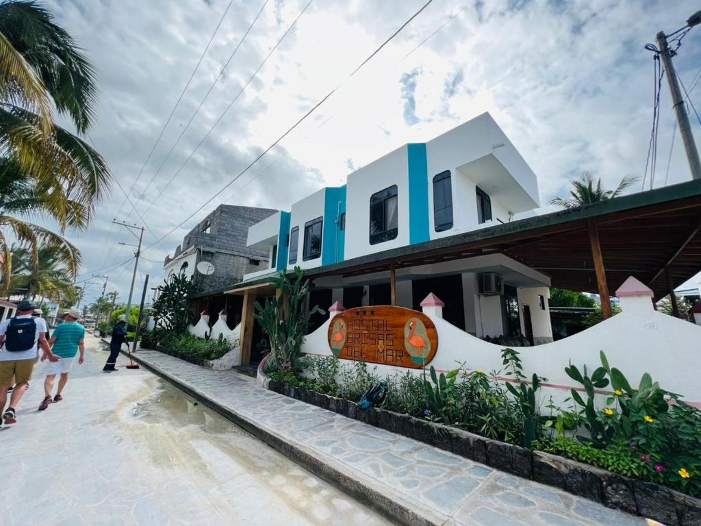 un bâtiment avec une planche de surf sur son côté dans l'établissement Hostal Brisas Del Mar, à Puerto Villamil