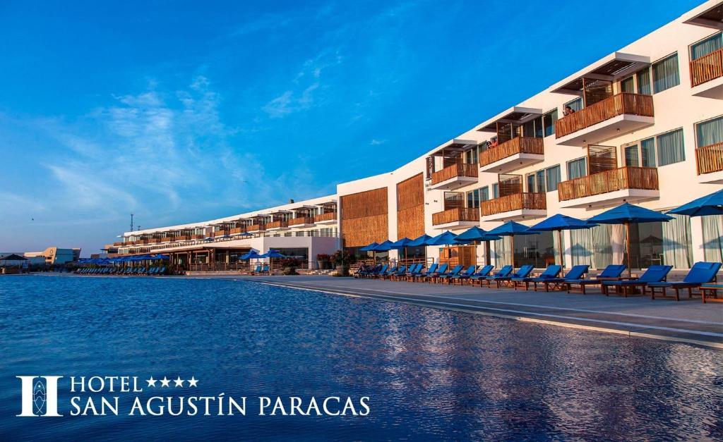 un edificio resort con sillas y una masa de agua en San Agustin Paracas, en Paracas