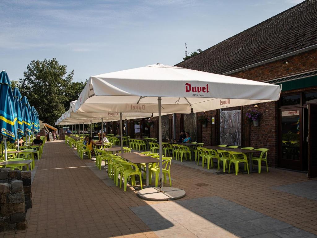 a group of tables and chairs under an umbrella at De Goolder in Bocholt