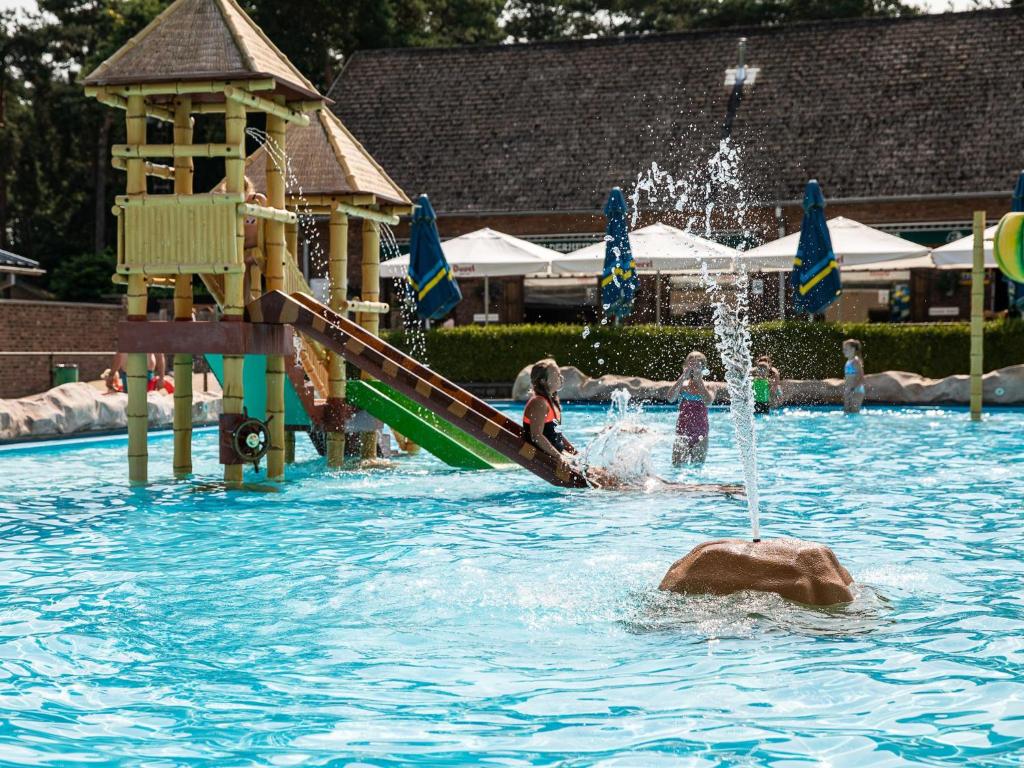 a group of children playing in a swimming pool with a fountain at De Goolder in Bocholt