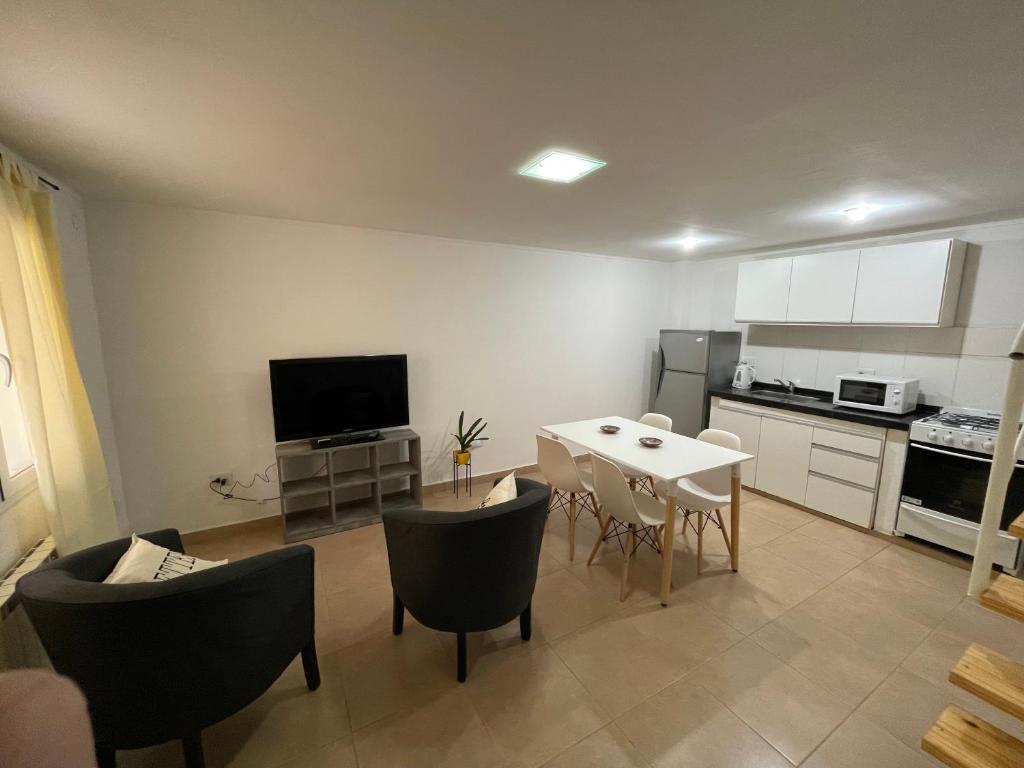 a kitchen and living room with a table and chairs at Aura in General Fernández Oro