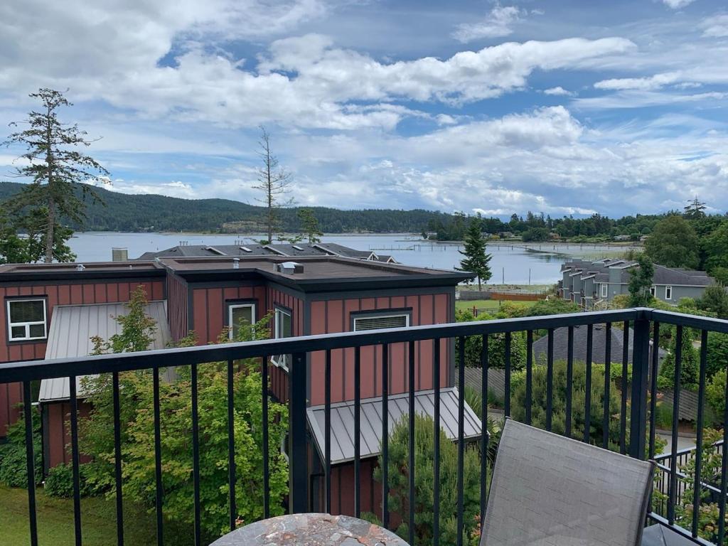 a red house with a view of a lake at Ocean View Townhome - Sooke Harbour Marina in Sooke