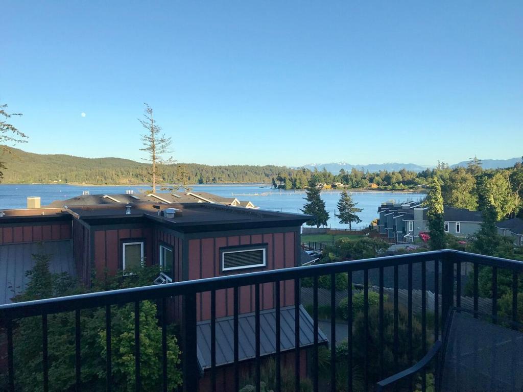 a house with a balcony with a view of a lake at Ocean View Townhome - Sooke Harbour Marina in Sooke