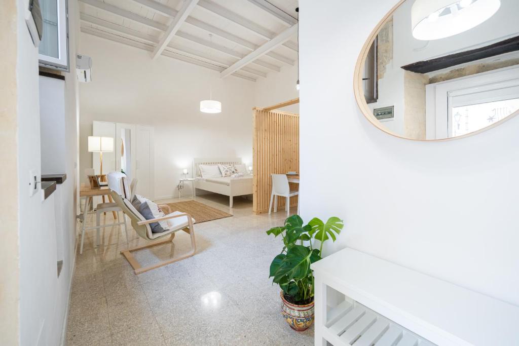 ein Wohnzimmer mit einem Sofa und einem Spiegel in der Unterkunft Cortile Santa Teresa in Syrakus