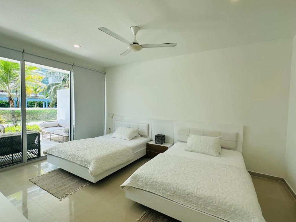 um quarto com 2 camas e uma ventoinha de tecto em MORROS EPIC 1111 em Cartagena de Indias