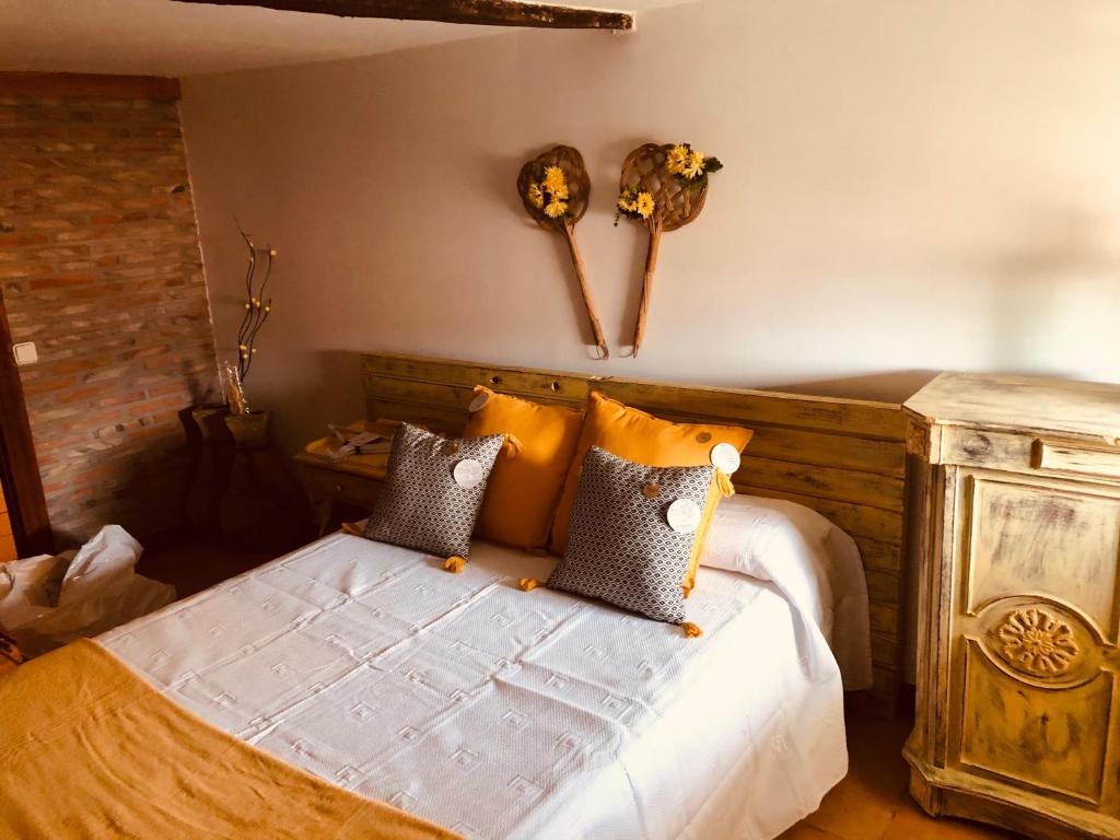 a bedroom with a bed with a wooden head board at Las maletas del pasiego in Quintana