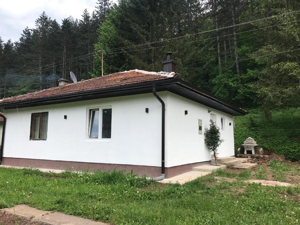 Biały dom z brązowym dachem w obiekcie Apartman Kosuta Lux w mieście Tjentište