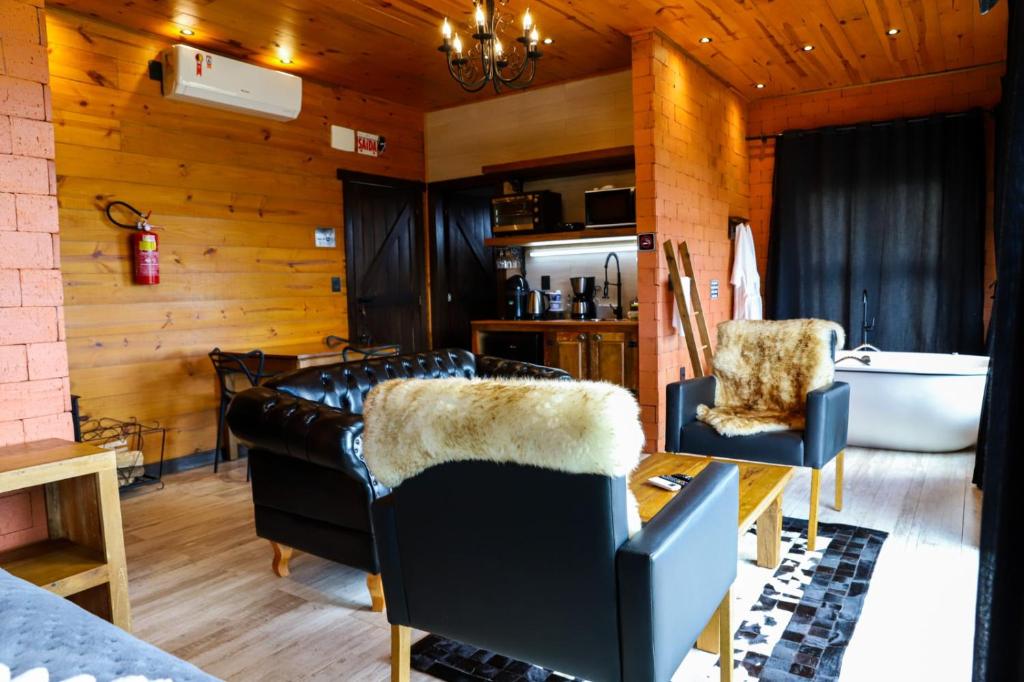 a living room with a tub and a couch and a bath tub at Infinity Valley Cabanas in Urubici