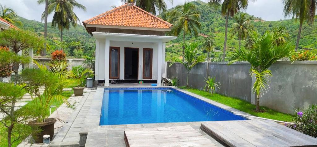 a villa with a swimming pool and a house at torok ocean homestay in Mataram