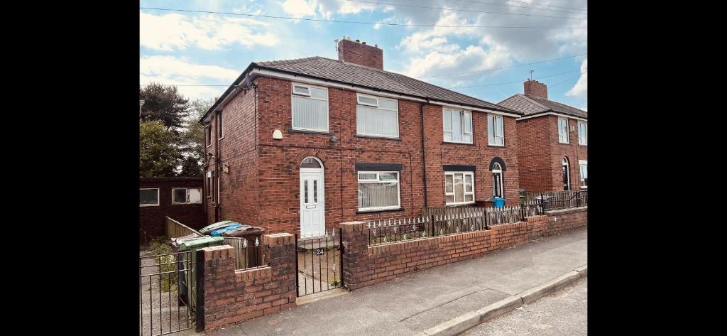una casa de ladrillo con una valla delante de ella en Entire 3-Bedroom Home in Oldham - Guest house en Oldham
