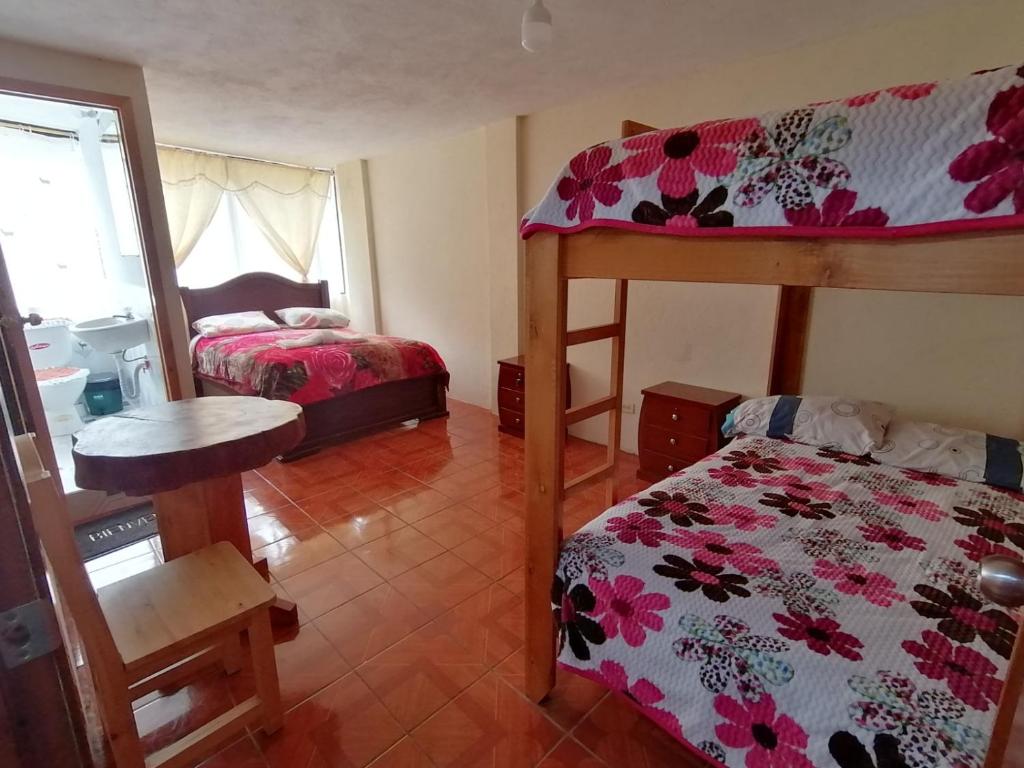 - une chambre avec deux lits superposés et un lit dans l'établissement Hostal backpackers, à Chugchilán