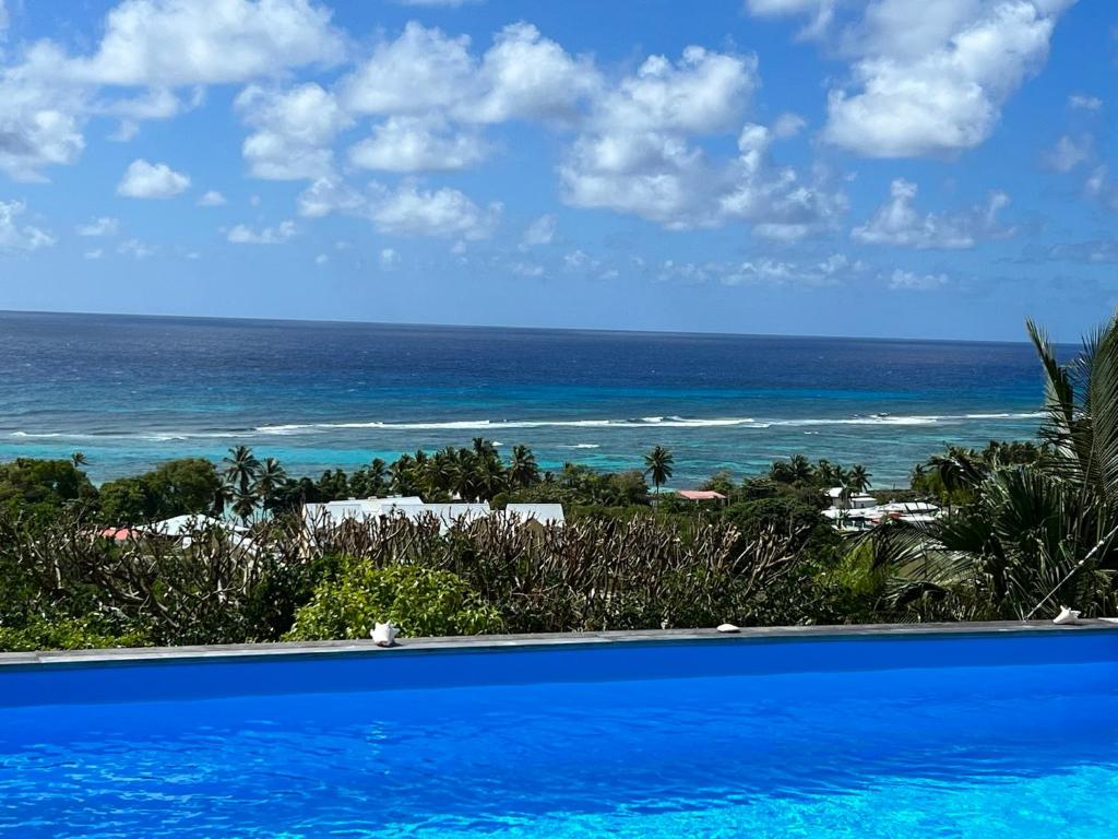 a swimming pool with the ocean in the background at La Villa By Ferdi'Nan in Grand-Bourg