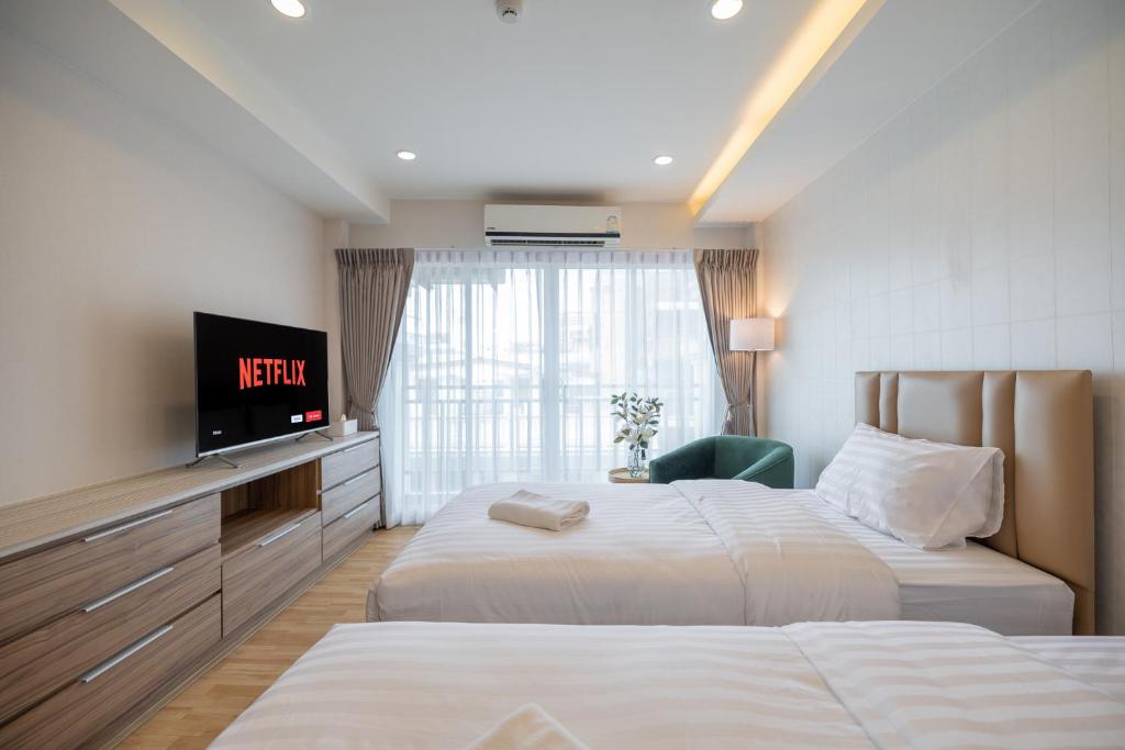 a hotel room with two beds and a flat screen tv at Exoresidence The Heart of Chinatown in Bangkok