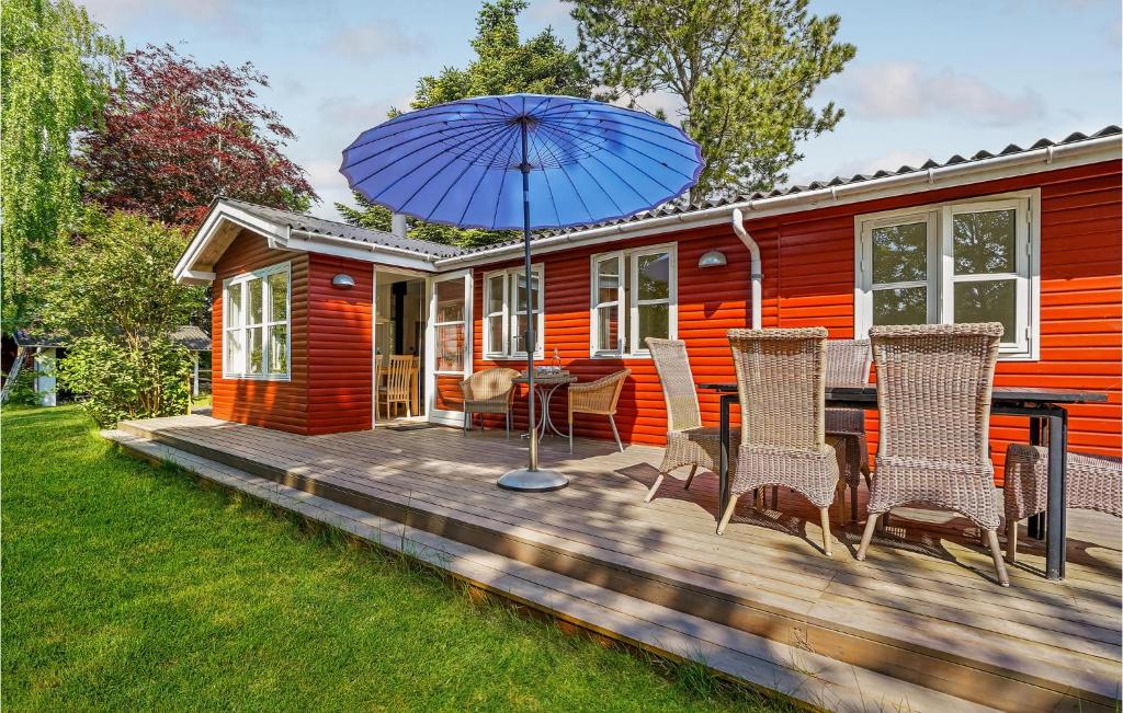 a wooden deck with chairs and an umbrella at Awesome Home In Malling With Wifi in Malling