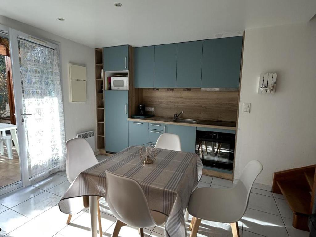 une salle à manger avec une table et des chaises dans une cuisine dans l'établissement Charmant pavillon avec piscine et animaux acceptés - Sorède - FR-1-732-32, à Sorède