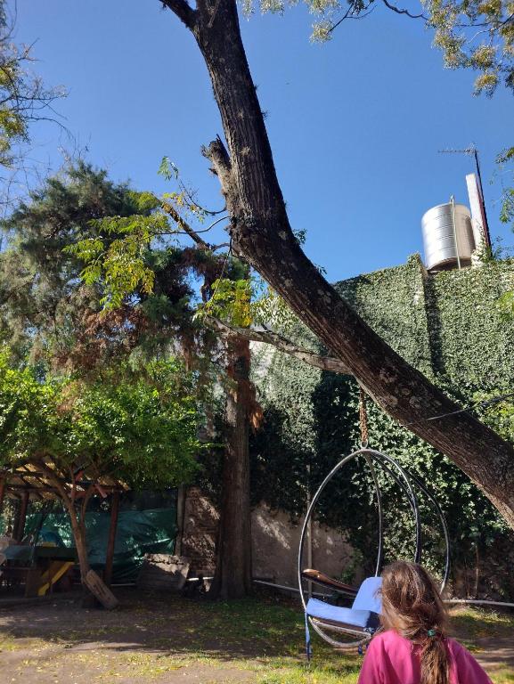 una mujer parada junto a un árbol con un columpio en Casa quinta Los Mellis en La Reja