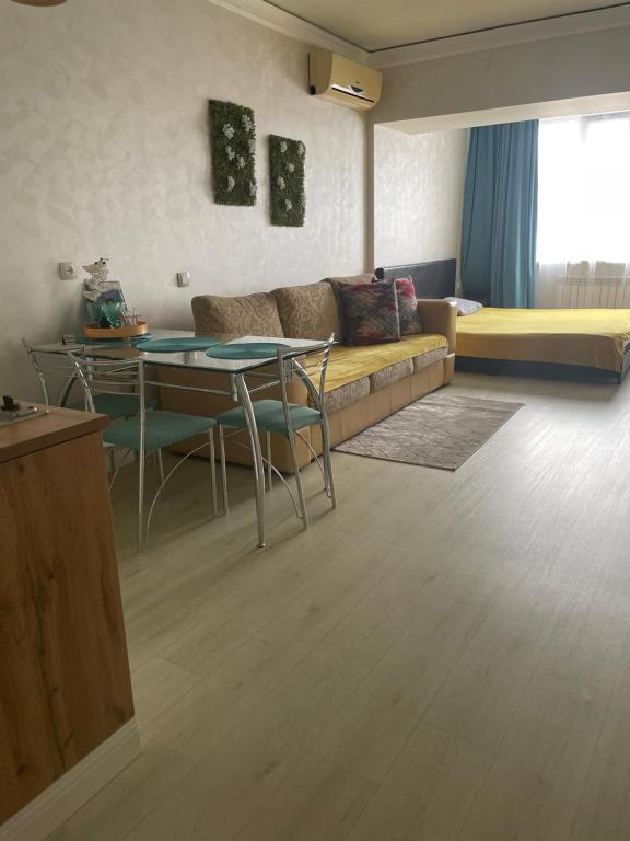 een woonkamer met een bank en een tafel bij Арбат apartment in Alma-Ata