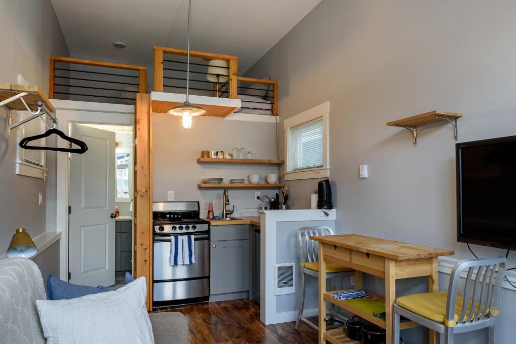 uma pequena cozinha com uma mesa e um fogão em Tiny House by KABINO Mini Modern TINY HOME Heart of Green Lake Pet Friendly WiFi Loft up Ladder plus Sleeper Sofa em Seattle
