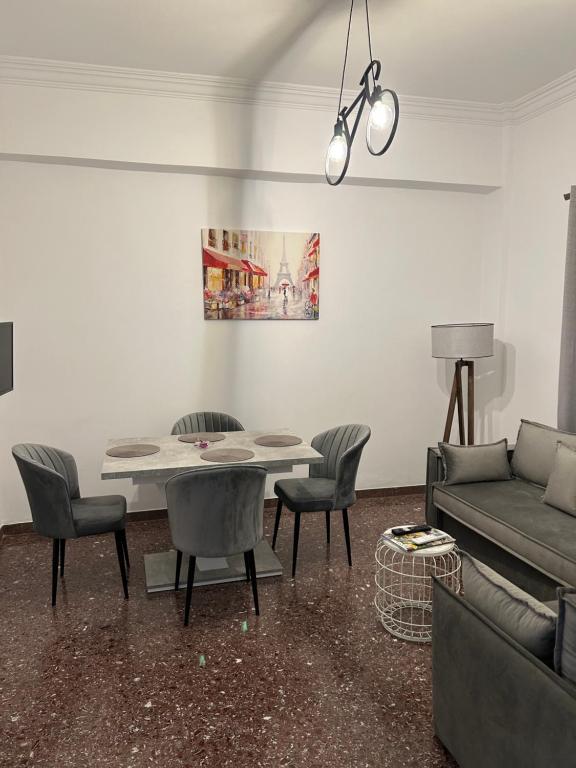 Technopolis Luxury Apartments في أثينا: غرفة معيشة مع طاولة وكراسي وأريكة