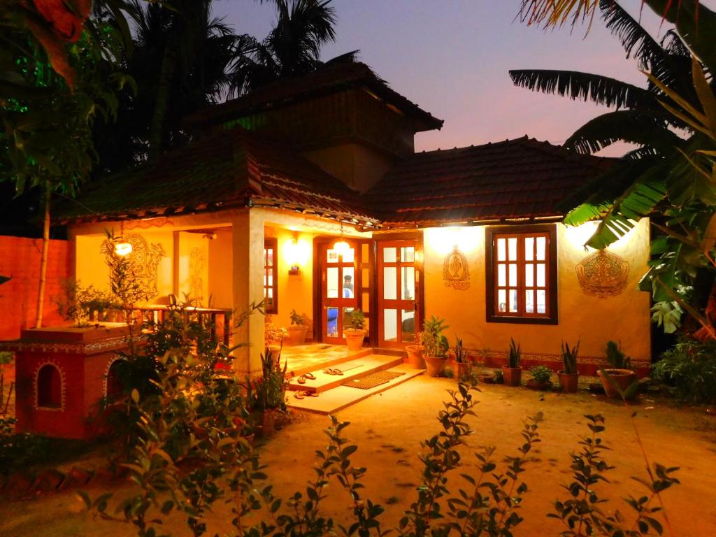 a house with a lit up front yard at night at Gram Bangla Retreat in Kolkata