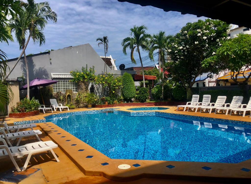 een zwembad met ligstoelen en een zwembad bij Southern Star Resort in Noord Pattaya