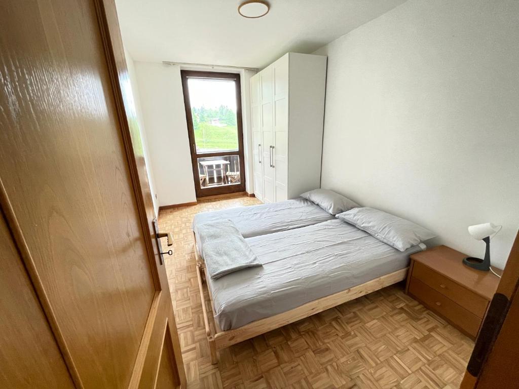 a small bedroom with a bed and a window at Lavarone Gasperi 1 - Spazioso appartamento in Lavarone