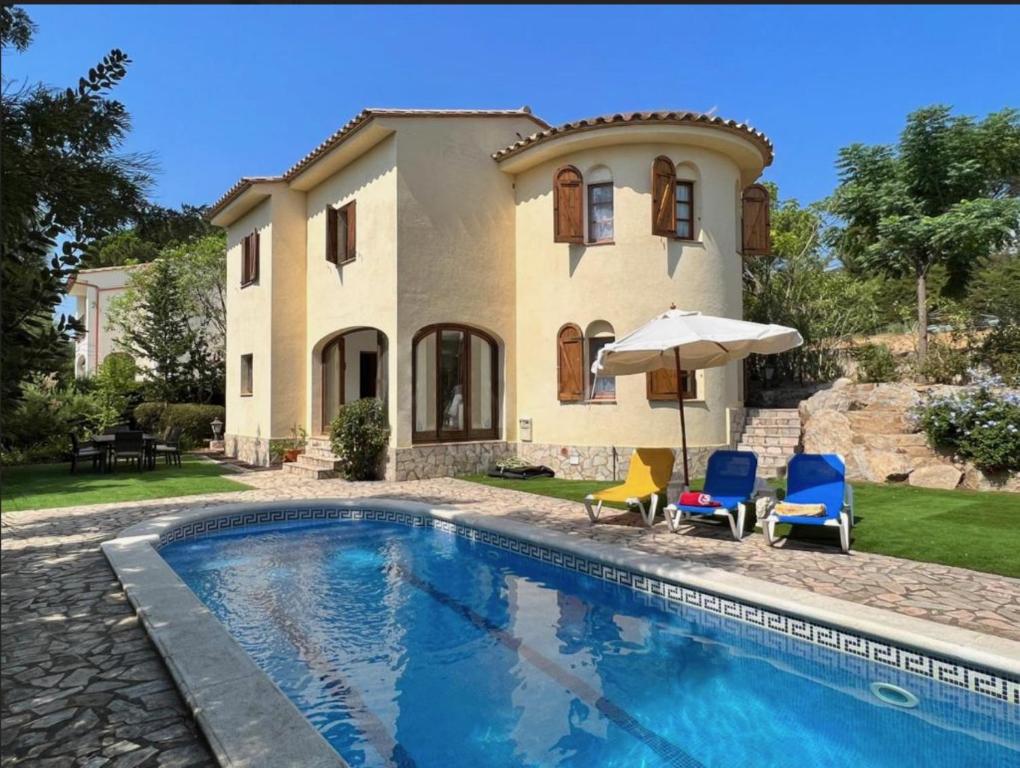 eine Villa mit einem Swimmingpool vor einem Haus in der Unterkunft VILLAS COSETTE Villa Brava in Calonge