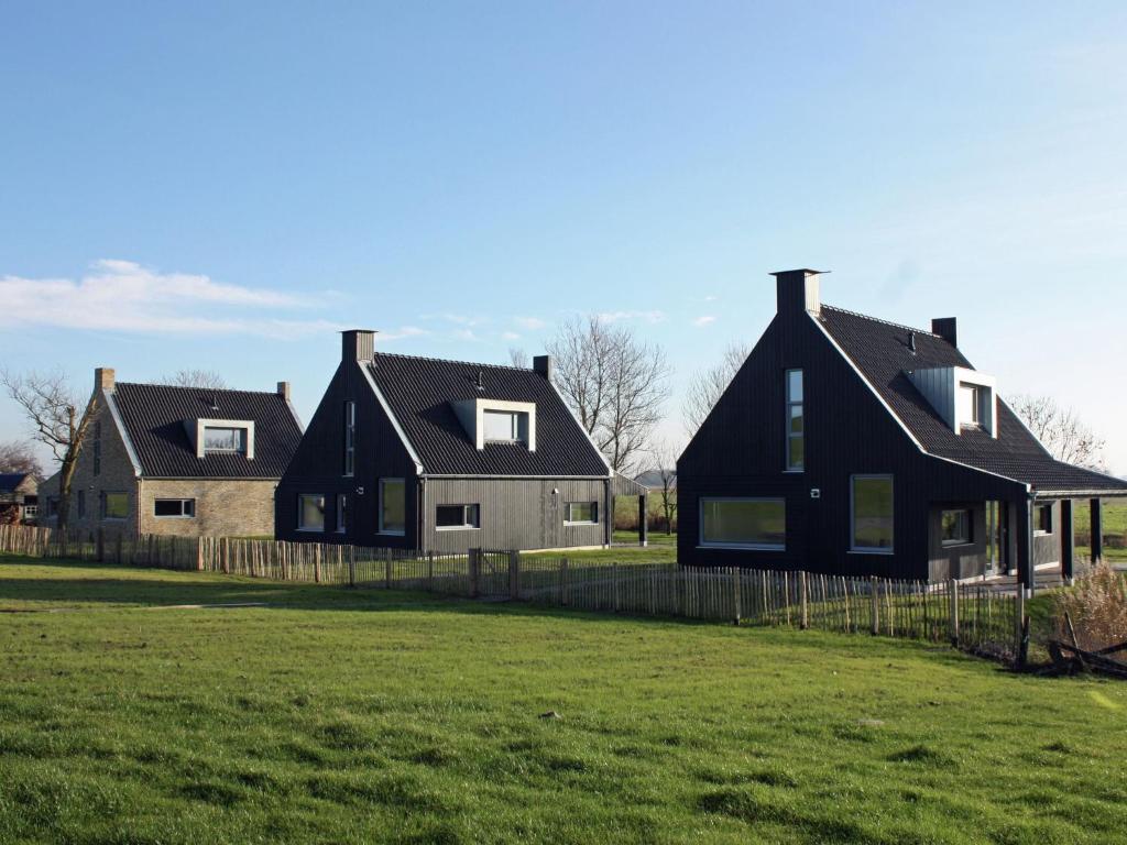 eine Gruppe von Häusern auf einem Feld mit Gras in der Unterkunft Classy Villa in Tzummarum with Terrace Garden in Tzummarum