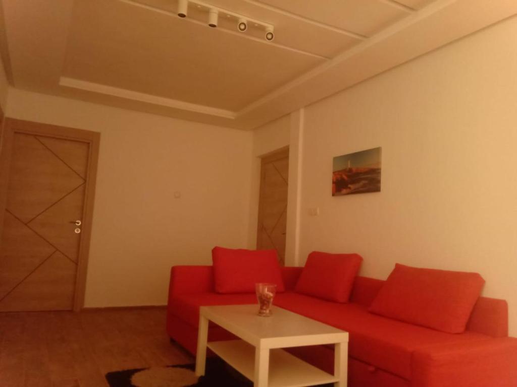 a living room with a red couch and a table at Apartment Hotel With Restaurant & Parking in Taza