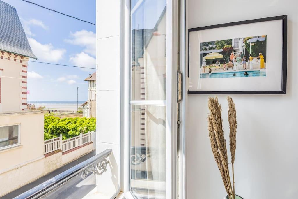 a door to a balcony with a view of the ocean at Studio front de mer en centre-ville de Cabourg in Cabourg