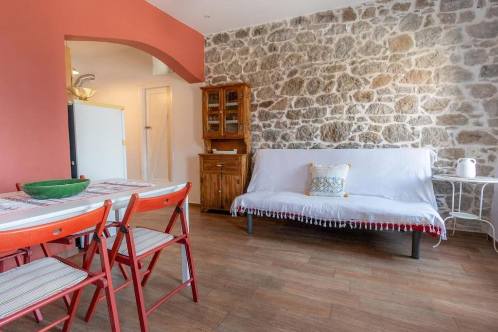 uma sala de estar com um sofá branco e uma parede de pedra em Annas Horizon em Samothráki