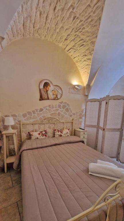 sypialnia z dużym łóżkiem w pokoju w obiekcie Appartamento Antico Pozzo w mieście Martina Franca