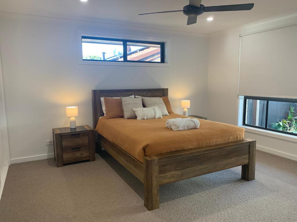 1 dormitorio con 1 cama con 2 lámparas y una ventana en Ranges Over the Bay, en Culburra Beach